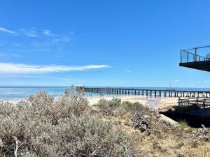 una spiaggia con un molo e persone nell'oceano di Kerrigan's on Seaview- one minute walk to beach - not beachfront views a Henley Beach South Altre 4 foto