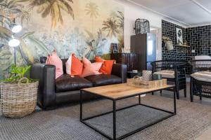 a living room with a leather couch and a coffee table at No 1 Dicks Street Apartment in Howick
