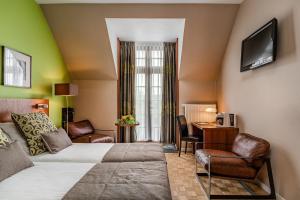 um quarto de hotel com uma cama, uma mesa e cadeiras em Hotel De Pupiter em Kluisbergen