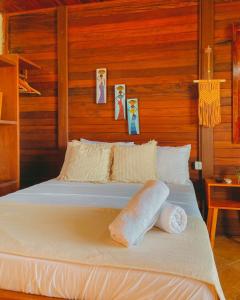 Ce lit se trouve dans un dortoir doté de murs en bois. dans l'établissement Pousada Dunas do Icarai, à Icaraí