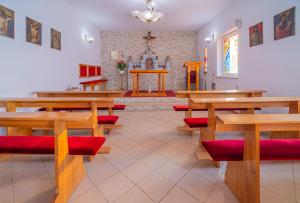 a church with wooden tables and benches and a altar at Nadmorski Dom Rekolekcyjny in Mrzeżyno