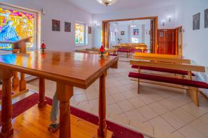 a room with benches and a table and a stained glass window at Nadmorski Dom Rekolekcyjny in Mrzeżyno