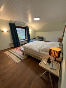 ein Schlafzimmer mit einem Bett und einem Tisch mit einer Lampe in der Unterkunft Wald Panorama Appartement in Battenberg