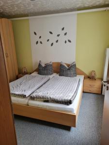 a bedroom with a bed with butterflies on the wall at Haus am Waldesrand in Tanne