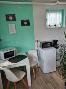 a room with a table and two chairs and a microwave at Haus am Waldesrand in Tanne +8 photos