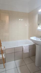 a white bathroom with a tub and a sink at Le Saint Vincent in Apremont