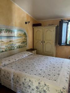 a bedroom with a bed and a painting on the wall at Orosei RE - Villa Samuela a 50 m dal mare in Orosei