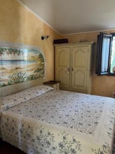 a bedroom with a bed and a painting on the wall at Orosei RE - Villa Samuela a 50 m dal mare in Orosei