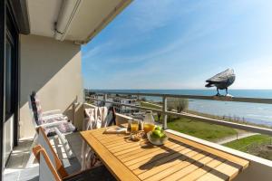 una mesa con un pájaro en un balcón con vistas al océano en Vier-Jahreszeiten-Haus-I-Wohnung-68, en Großenbrode