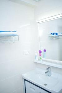 ein weißes Badezimmer mit einem Waschbecken und einem Spiegel in der Unterkunft Casamia Apartments in Nairobi