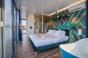 a bedroom with a large bed and a tub at Escale Royale Port Ilon in Saint-Martin-la-Garenne