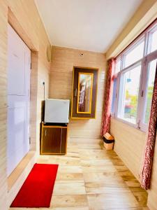 a room with a door and a red rug at Grand view lodge and Restaurant Dharamshala - Partial Prepayment required to confirm booking in Dharamshala
