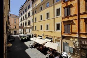 Une allée avec des tables et des parasols devant les bâtiments dans l'établissement Youroom Vite, à Rome