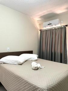 un letto con un animale di peluche sopra di esso di HOTEL SAYMON a Cafelândia