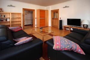 ein Wohnzimmer mit 2 Sofas und einem Couchtisch in der Unterkunft Komfort-Ferienwohnung "Zur Schmiedebrücke" in Großschönau