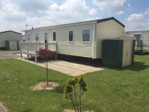a mobile home in a yard with a building at Summer Dreams Holiday Home in Skegness