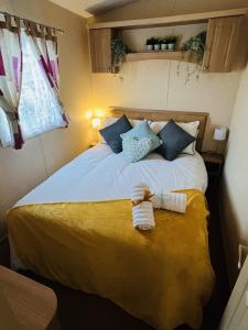 a bedroom with a bed with towels on it at Summer Dreams Holiday Home in Skegness