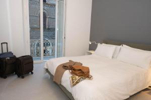 Un dormitorio con una cama blanca con una bolsa. en Rosselli 74 by Arbaspàa en La Spezia