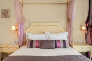 a bedroom with a large bed with pink curtains at Danai Hotel & Spa in Olympic Beach