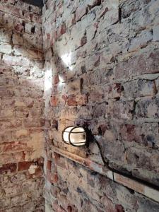 a brick wall with a light on it at La petite Madeleine Paisible - Contemporain - 2Ch in La Madeleine