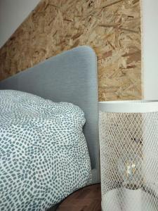 a bedroom with a blue bed and a wooden floor at La petite Madeleine Paisible - Contemporain - 2Ch in La Madeleine