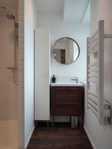 a bathroom with a sink and a mirror at La petite Madeleine Paisible - Contemporain - 2Ch in La Madeleine