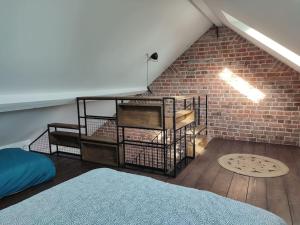a attic room with a brick wall and a bed at La petite Madeleine Paisible - Contemporain - 2Ch in La Madeleine