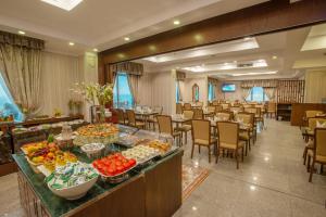 a banquet hall with tables and chairs and food on a buffet at City Tower Hotel in Kuwait