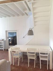 een eetkamer met een witte tafel en stoelen bij Ottenstein in Hierden