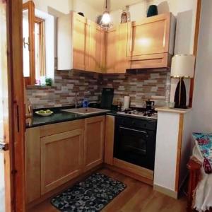 cocina con armarios de madera, fregadero y fogones en Appartamento Residence Monte D'Ocre en Rocca di Cambio