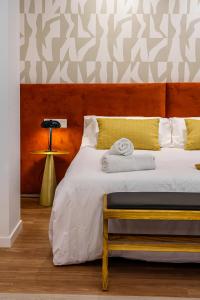 a bedroom with a large bed with a wooden headboard at SUNSET MALAGA Exclusive Alameda in Málaga