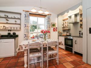 a kitchen with a table with flowers on it at The Shippen in Bude