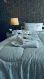 białe łóżko z ręcznikami na górze w obiekcie White House Cottages w mieście Murree