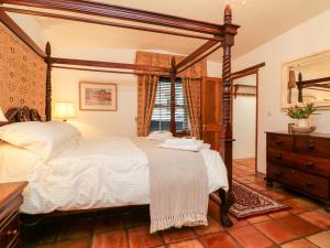 a bedroom with a canopy bed and a dresser at The Shippen in Bude