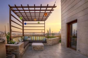 a rooftop patio with a couch and a pergola at Mira Trio Hotel - Riyadh - Tahlia Street in Riyadh