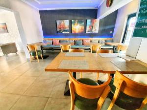 une salle à manger avec des tables, des chaises et un tableau noir dans l'établissement Phudzi Hotel, à Letlhakawe
