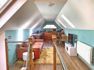 uma sala de estar com um sofá e uma cozinha em Chy Glynn. Luxury lodge with hot tub and views. em St. Agnes