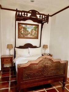 a bedroom with a wooden bed and two lamps at Casa Simeon in Bacacay
