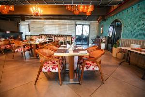 a dining room with tables and chairs in a restaurant at Regenta Place Jhansi by Royal Orchid Hotels Limited in Jhānsi