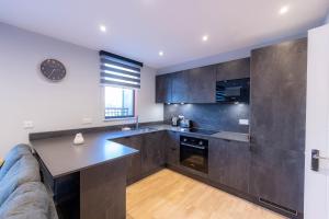 a kitchen with a couch and a table in a room at Luxurious Apartments Hackney near Train Station in London