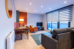 uma sala de estar com um sofá e uma mesa em Luxurious Apartments Hackney near Train Station em Londres