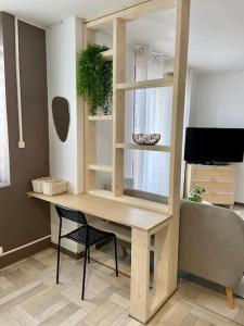 Zimmer mit einem Schreibtisch mit Stuhl und einem TV in der Unterkunft Studio avec Balcon proche Gare in Bourg-en-Bresse