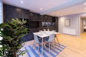 a dining room with a white table and chairs at Luxurious Apartments Hackney near Train Station in London