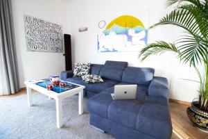 - un salon avec un canapé bleu et une table dans l'établissement Villa Titina - Sunset Apartments, à Ischia