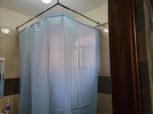 a shower curtain is hanging in a bathroom at Cozy Apartment in Ruaka