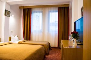アラドにあるHotel Rigaのベッド2台とテレビが備わるホテルルームです。