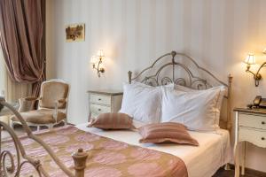 a bedroom with a bed with pillows and a chair at Danai Hotel & Spa in Olympic Beach
