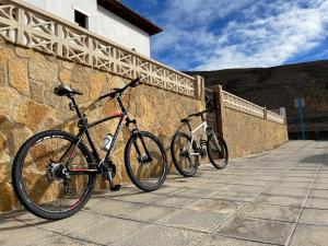 dos bicicletas estacionadas junto a una pared de piedra en Casa Mararía en Gran Tarajal