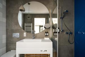 uma casa de banho com um lavatório branco e um espelho. em FREIgeist Göttingen Innenstadt, A Member of Design Hotels em Göttingen