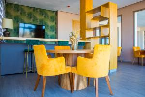a dining room with a table and yellow chairs at Valley Boutique Hotel in Safi